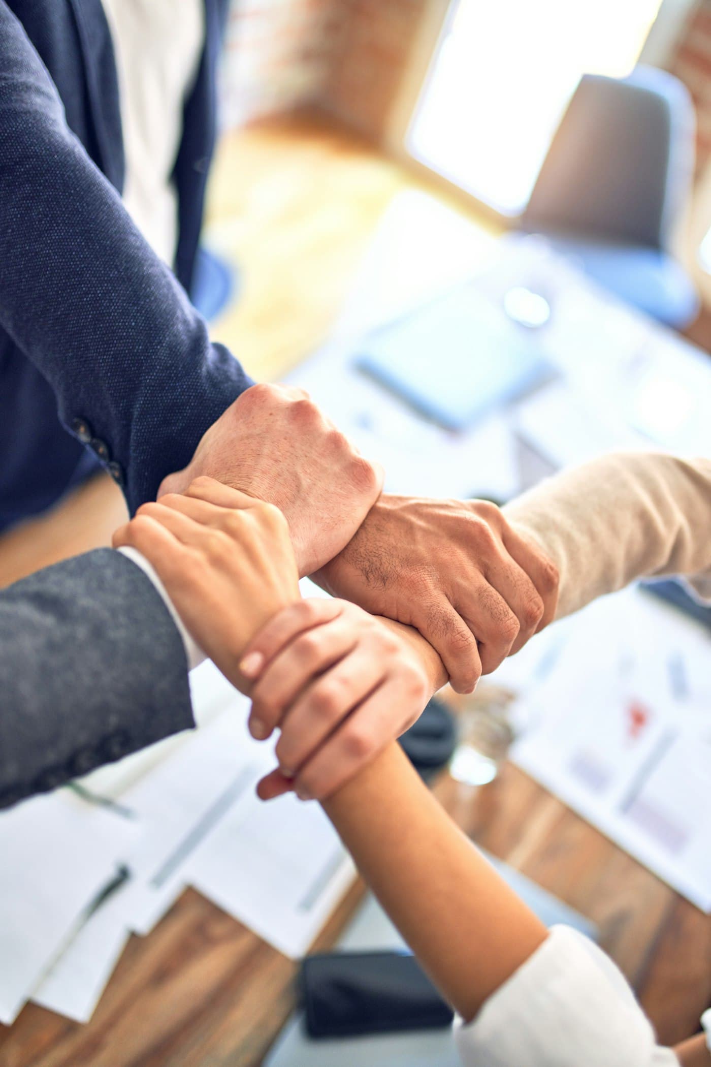 Colleagues joining hands in a show of teamwork